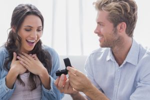 A woman smiles at her partner as they pull out a ring. Learn how a premarital counselor in Phoenix, AZ can offer support by searching premarital counselor near me today. A therapist in Arcadia, AZ can help you today!