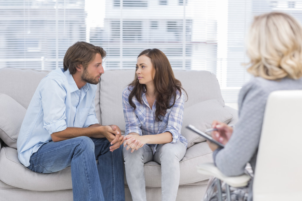 A couple on a couch talk with one another while a person with a notepad sits across from them. This could represent how couples therapy in Scottsdale, AZ can support your relationship. Learn more about counseling in Scottsdale, AZ by contacting a couples therapist in Scottsdale, AZ today.