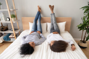 A teen lays on a bed while talking to their parent. Learn how counseling for teens in Phoenix, AZ can offer support for you and your teen. Contact a teen therapist in Phoenix, AZ today or search “therapist in Arcadia, AZ” today.