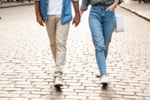 A couple walk down a stone road while holding hands. This could symbolize the deeper connection cultivated by a premarital counselor in Phoenix, AZ. Learn more about premarital counseling in Phoenix, AZ by contacting a therapist in Arcadia, AZ for more info.