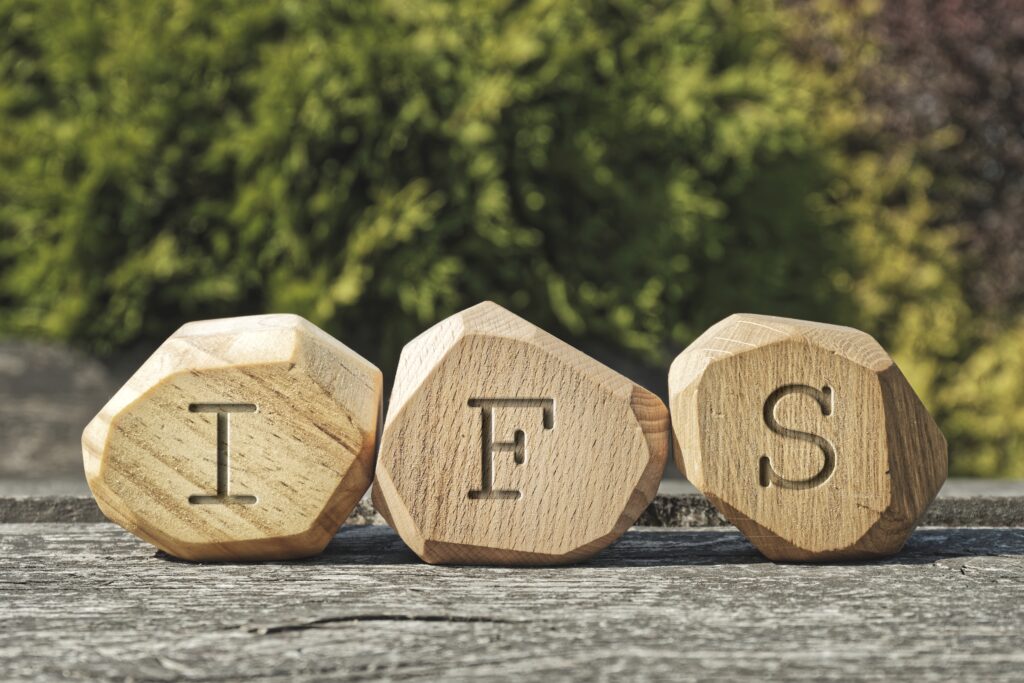 A close-up of wooden blocks with the text IFS. Learn more about IFS therapy in Phoenix, AZ by contacting an IFS therapist in Phoenix, AZ today.