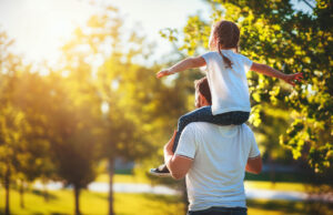 A father gives a piggyback ride to their daughter as they walk through a sunny park. A child therapist in Phoenix, AZ can offer support in talking with your child. Learn more about child counseling Phoenix AZ by contacting a therapist in Arcadia, AZ today.