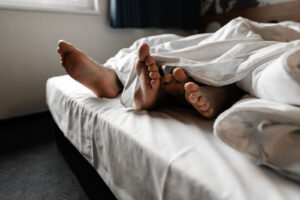 An image of a couple's feet at the end of a bed. Couples therapy in Phoenix, AZ can offer support for couples across AZ. Learn more about therapy in Arcaida, AZ and other serives by searching "counseling phoenix az" today. 