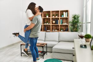 A couple embrace and kiss passionately in their living room. This represents the support couples therapy in Phoenix, AZ can offer. Learn more about therapy in Arcadia, AZ today by searching "relationship coach Phoenix" today for more info.
