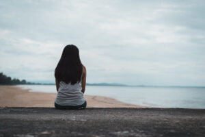 A person sits alone while looking out at a cloudy shore. This could symbolize the loneliness that an anxiety therapist in Arcadia, AZ can help you overcome. Learn more about anxiety treatment in Biltmore, AZ and other services to support you today. 